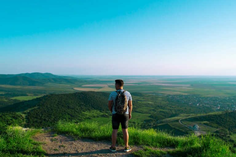 Homem em cima da montanha refletindo sobre crescimento pessoal