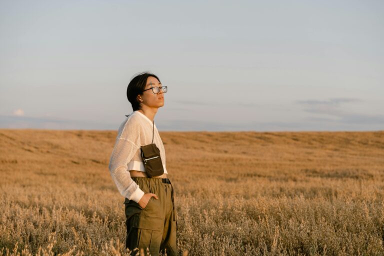 Mulher olhando para o horizonte ao nascer do sol, simbolizando um novo começo